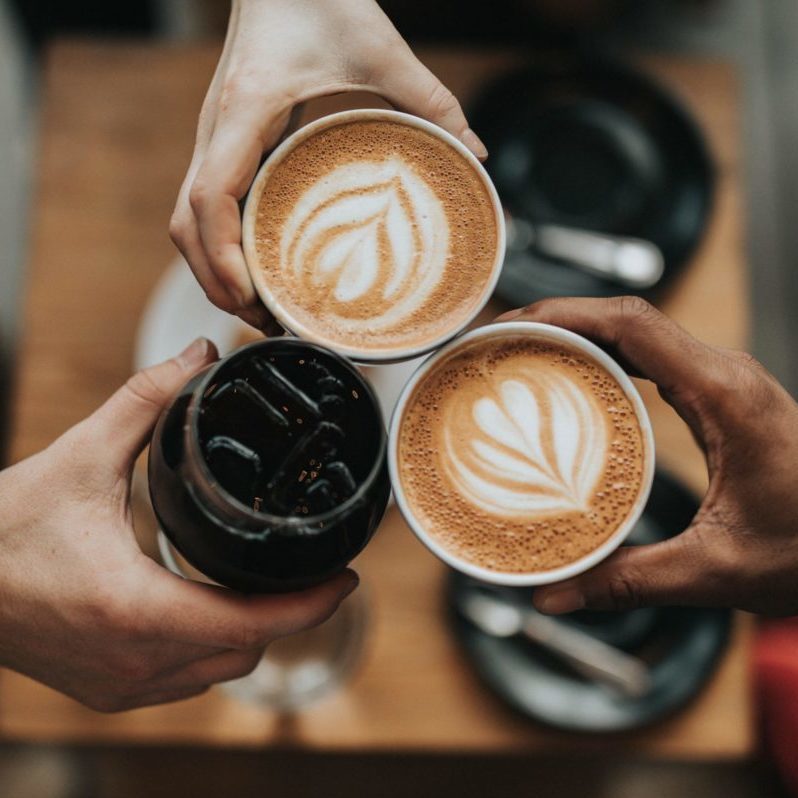 Cafes portada three person holding beverage cups